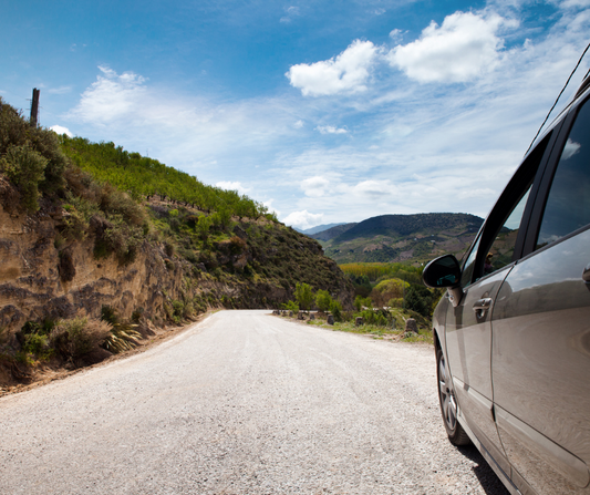 car on the road with mountain view, car with starlink, blue sky 