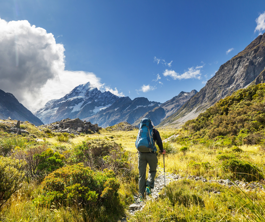 man with blue camping bag and hiking in the mountains 